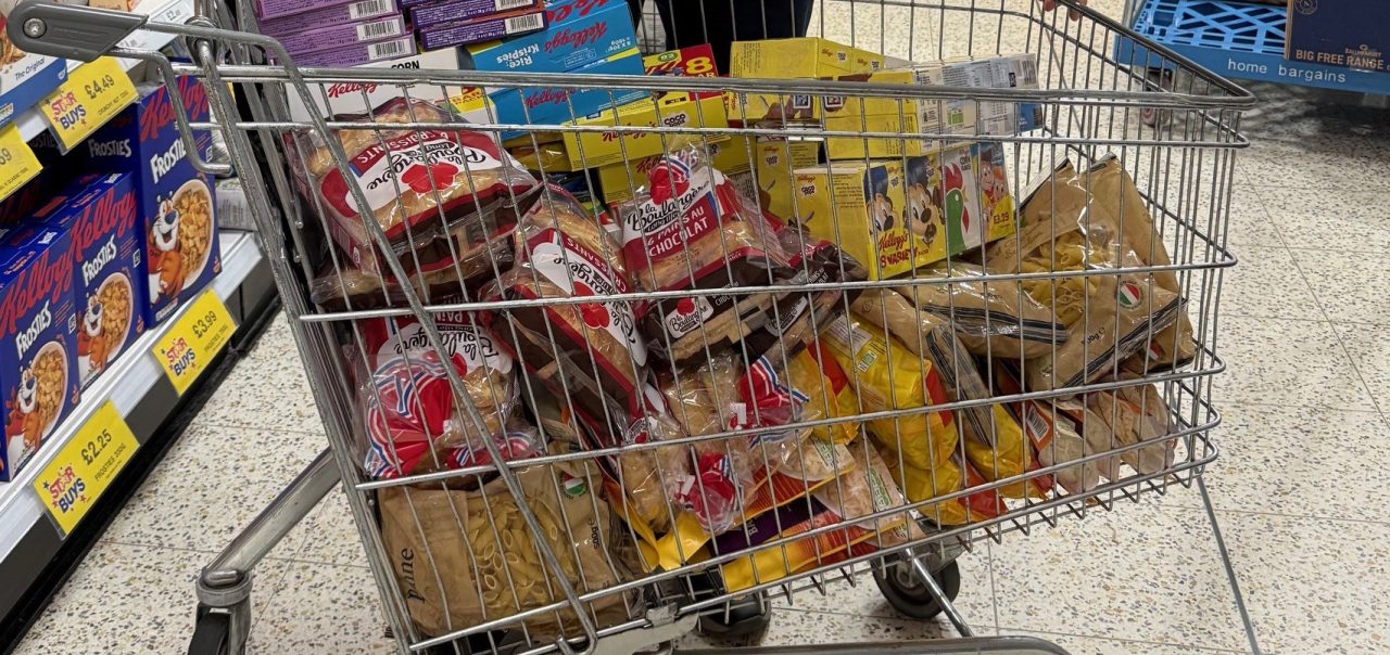 Shopping trolley full of foodbank goods.