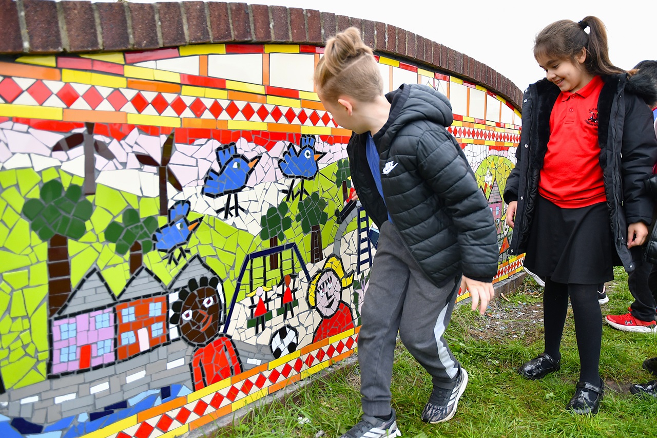 Children by the new mosaic at Moorland Park in Newport