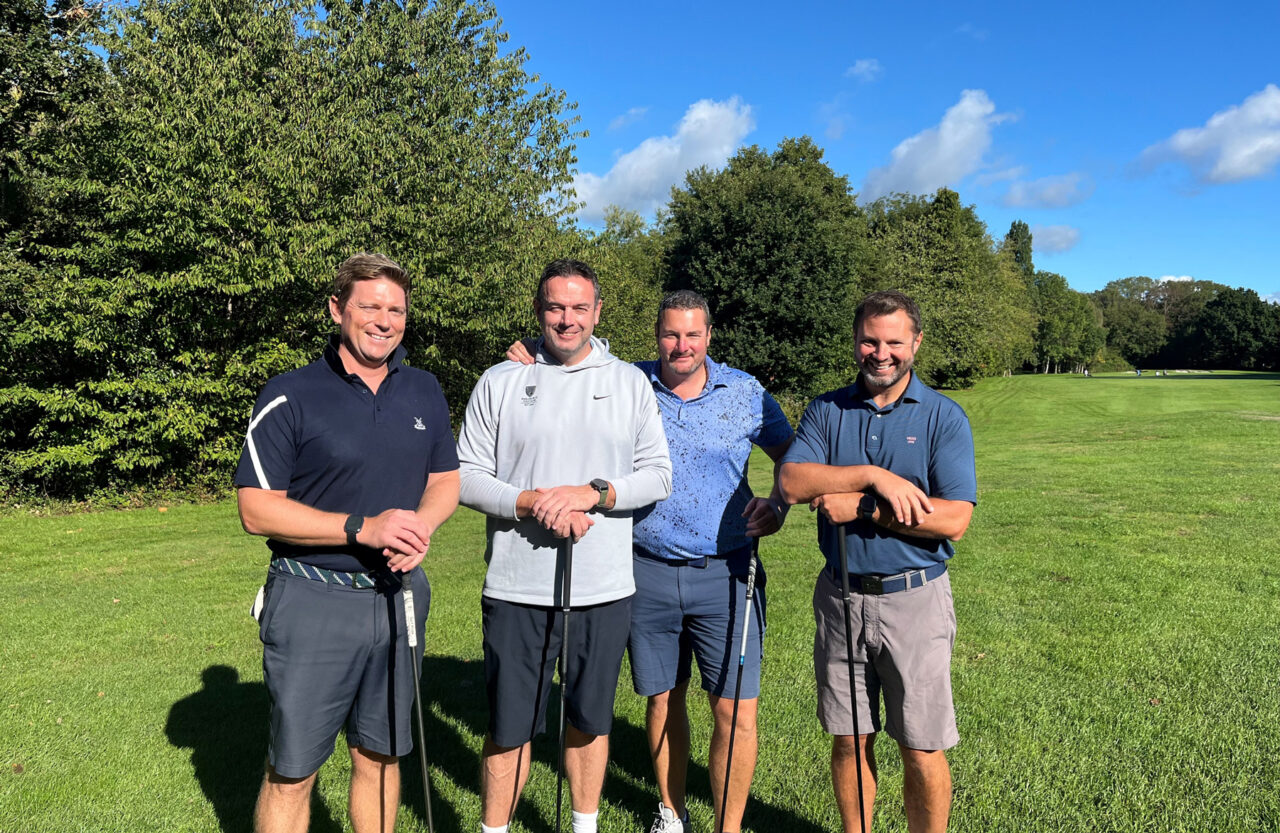 The Hugh James golf team stood together on the green.